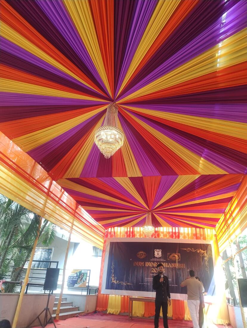 A vivid multicolour sunburst fabric ceiling with a hanging crystal chandelier