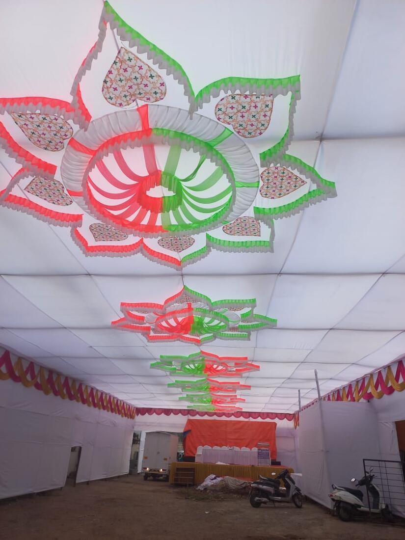 A red and green lotus-shaped fabric ceiling installation with patterned petals